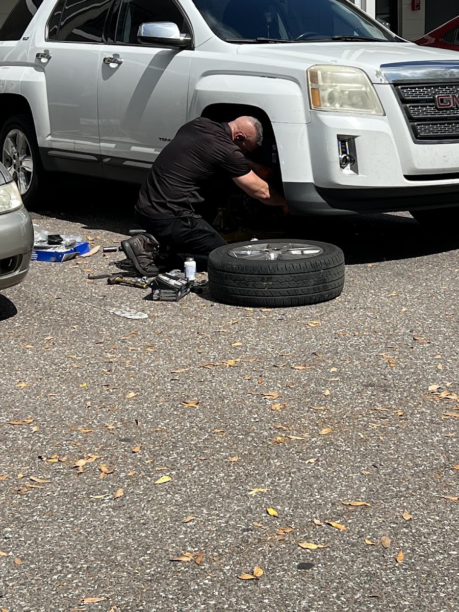 Mechanic in orange gloves working on a Cadillac engine